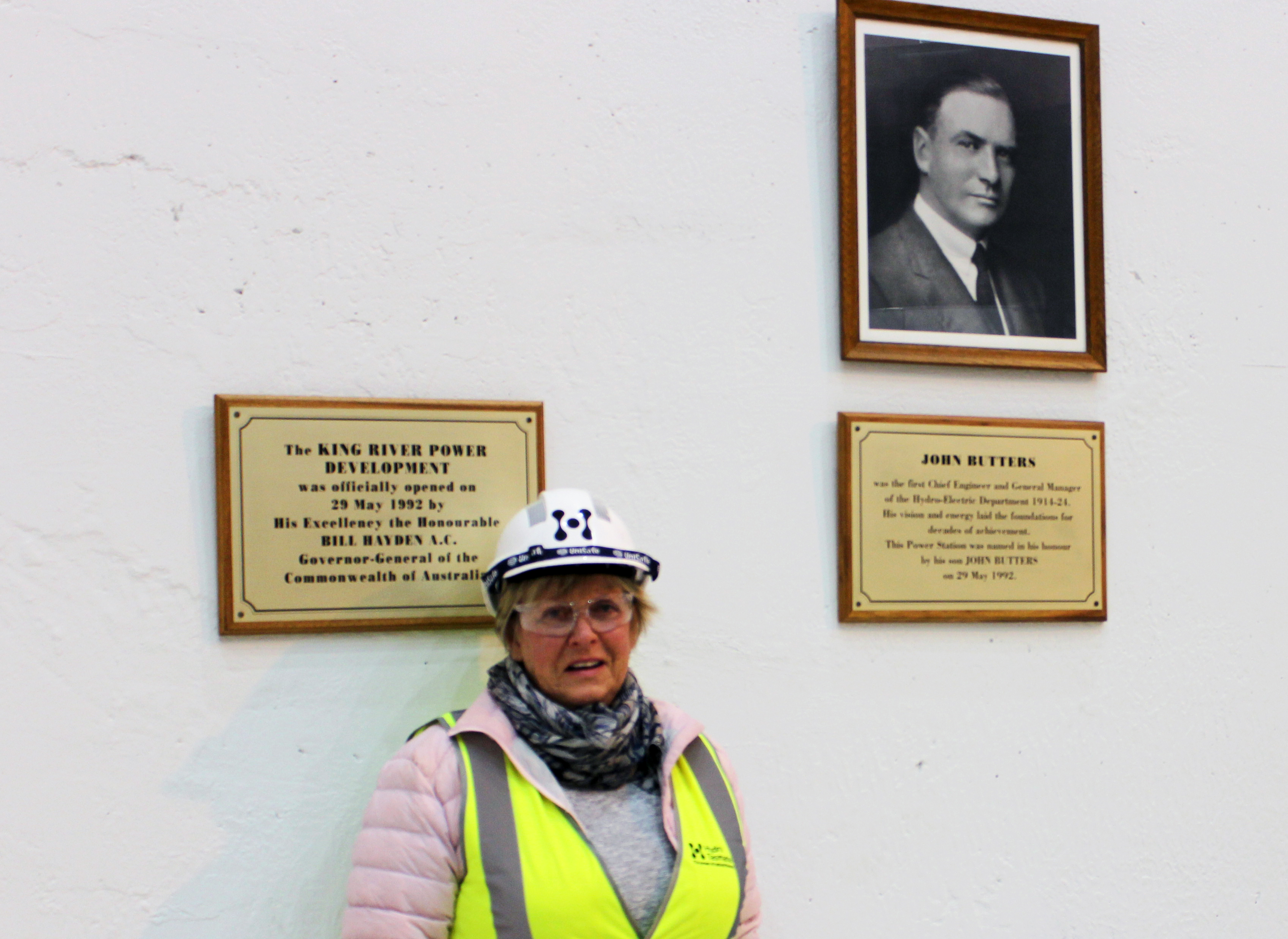 Penny Herold stands below a portrait of her grandfather at John Butter Power Station