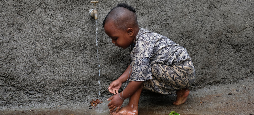 A little girl getting clean at the new well installation at her village