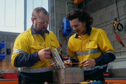 Two people in hi-vis working with tools