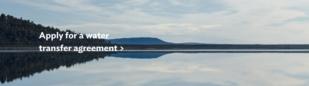 Outlook over a lake on a calm day, with text reading "Apply for a water transfer agreement >"