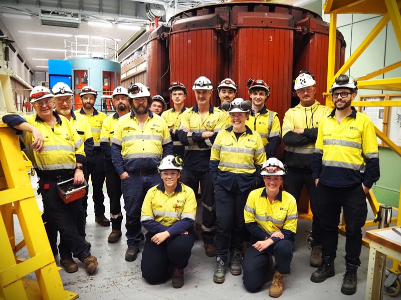 Group of people in high vis and helmets inside a power station