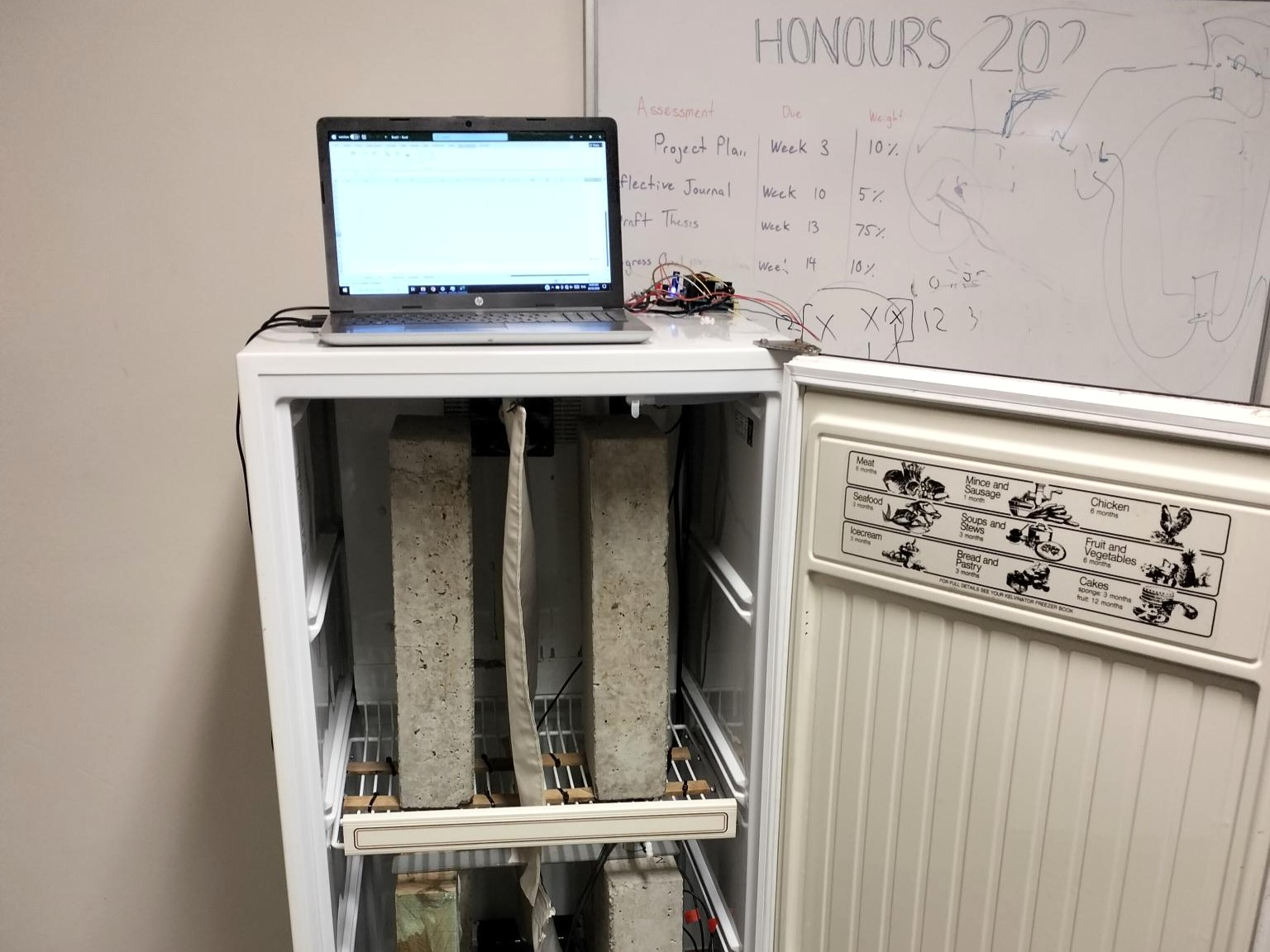An open converted freezer with concrete samples inside