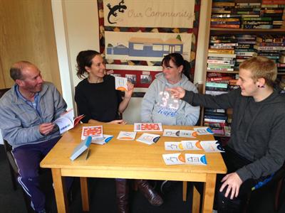 Four people sitting around a table studying using flash cards