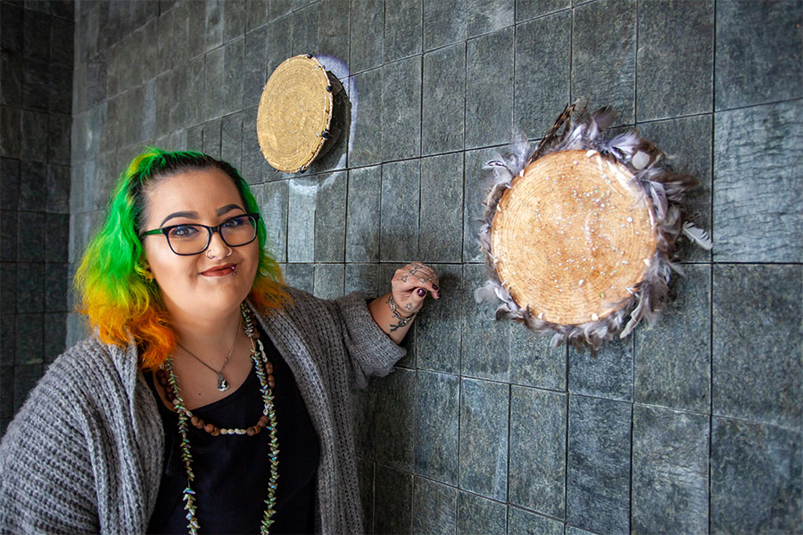 Bianca Templar standing next to her artwork 'From Coast to Country', hanging on the wall at the Hydro Tasmania Hobart head office.