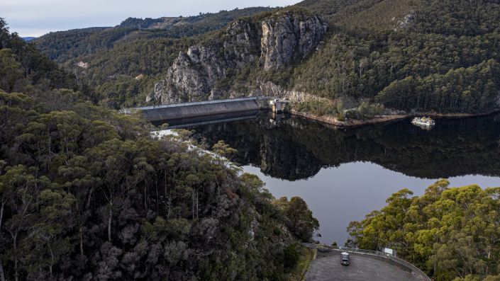 Dam surround by forest with cloudy skies
