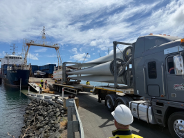 Wind turbine blades coming off a ship on the back of a truck