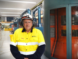 Man in high vis and helmet standing in a power station